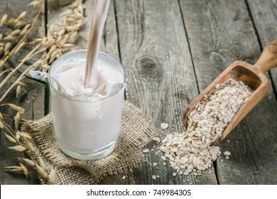 Pouring Oat Milk On Rustic Wood Background, Copy Space