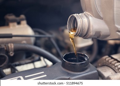 Pouring oil to car engine, close up