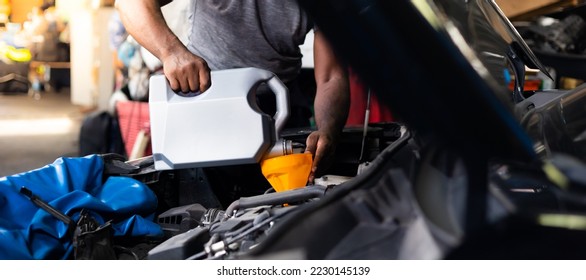 Pouring oil to car engine. Closue up male mechanic hand working  and service in Car Service station