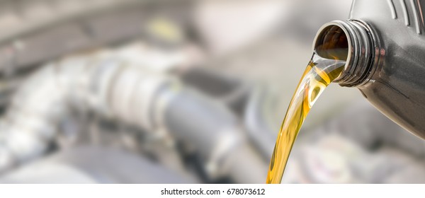 Pouring oil to car engine. Fresh oil poured during an oil change to a car.