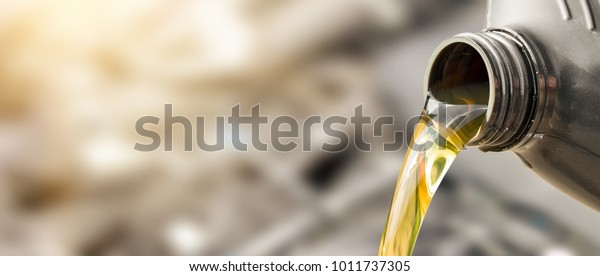 Pouring oil to car engine. Fresh oil poured during\
an oil change to a car.