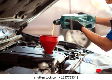 Pouring oil to car engine, Mechanic pouring oil into car at the repair garage