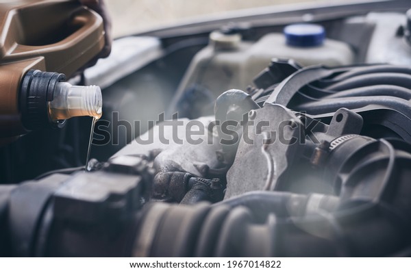 Pouring oil into car\
engine