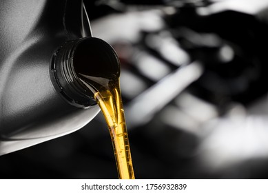 Pouring oil lubricant motor car from black bottle on engine background oil change auto shop