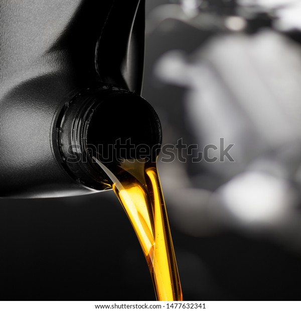 Pouring oil lubricant motor\
car from black bottle on engine background object transportation\
design