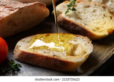 Pouring oil onto slices of bread on wooden plate, closeup - Powered by Shutterstock