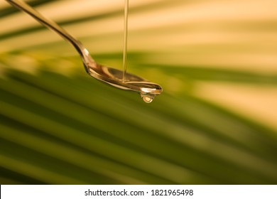 Pouring oil using serving spoon,pure coconut oil pouring  using silver spoon with coconut leaf in background - Powered by Shutterstock