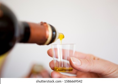Pouring olive oil into a tasting cup