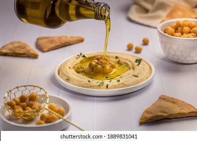 Pouring Olive Oil On Hummus Plate