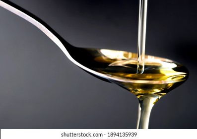 Pouring Olive Oil In The A Spoon At Kitchen. Prepare For Cooking Concept. Healthcare And Beauty Concept.