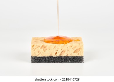 Pouring orange detergent on sponge isolated on white background. Orange liquid dish soap on sponge, home cleaning concept. Dishwashing sponge for general cleaning day - Shutterstock ID 2118446729