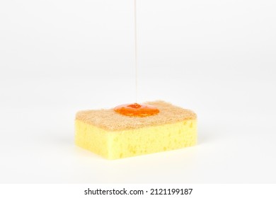 Pouring orange detergent on sponge isolated on white background. Orange liquid dish soap on sponge, home cleaning concept. Dishwashing sponge for general cleaning day - Shutterstock ID 2121199187