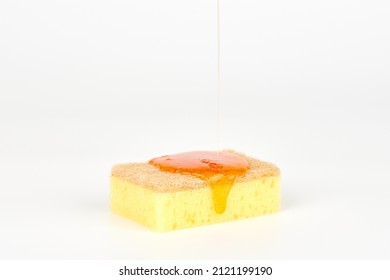 Pouring orange detergent on sponge isolated on white background. Orange liquid dish soap on sponge, home cleaning concept. Dishwashing sponge for general cleaning day - Shutterstock ID 2121199190