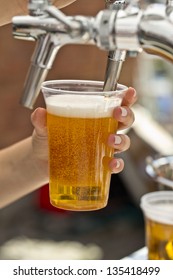 Pouring A Plastic Glass Of Beer