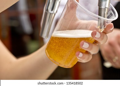 Pouring A Plastic Glass Of Beer