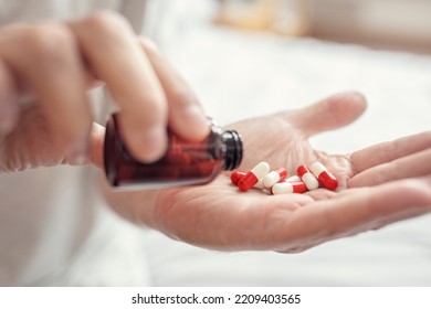 Pouring Prescription Drugs Capsules From A Medicine Pill Bottle Into Hand Daily Morning Routine