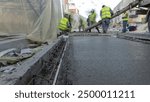 Pouring ready-mixed concrete after placing steel reinforcement to make the road by concrete mixer timelapse hyperlapse. New rails covered by tent. Reconstruction of tram tracks