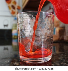 Pouring Red Drink Into Glass