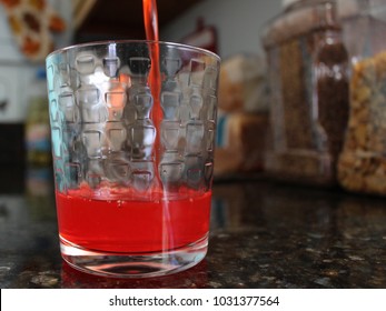 Pouring Red Drink Into Glass