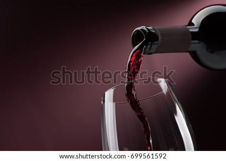 Pouring red wine from a bottle into a wineglass: wine tasting and celebration Foto stock © 