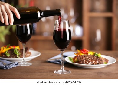 Pouring red wine into glass at lunch time - Powered by Shutterstock