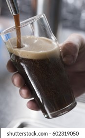 Pouring Refreshing Stout Beer In Glass From Tap 