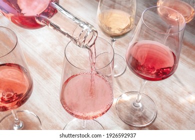 Pouring Rose Wine, Glasses Of Various Wine On A Wooden Table