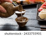 Pouring sake, Japanese sake seating, hand holding a cup