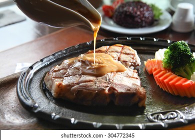 Pouring Sauce On Grilled Medium-rare Beef Steak