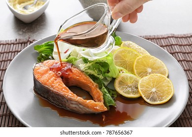 Pouring Sauce Onto Tasty Rainbow Trout Steak On Plate