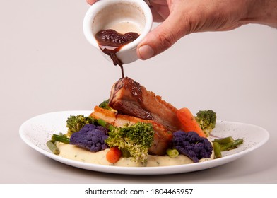 Pouring Sauce Over A Beautiful And Colored Meal - Pork Meat