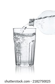 Pouring Soda Water From Bottle Into Glass On White Background