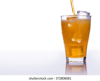 Pouring Soft Drink In A Glass With Ice On An Isolated White Background