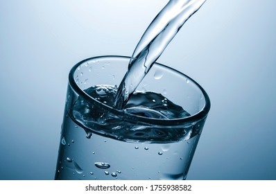 Pouring Sparkling Water Into A Glass In Close Up On The Rim Of The Almost Full Glass With Effervescent Bubbles