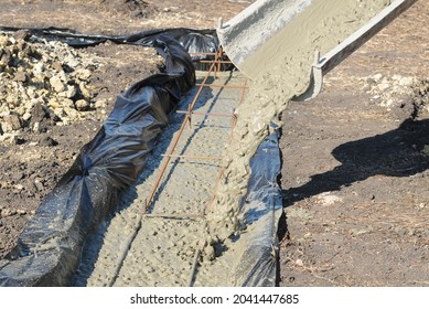 Pouring of strip foundations with reinforcement and waterproofing Concrete delivery along the sleeve.