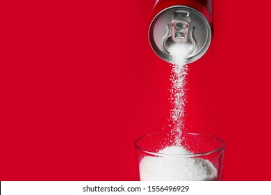 Pouring of sugar from can into glass on color background