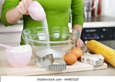 Pouring sugar into mixing bowl with ingredients for making cookies - Powered by Shutterstock