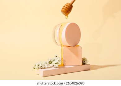 Pouring Of Sweet Honey Onto Jar Of Cosmetic Product On Color Background