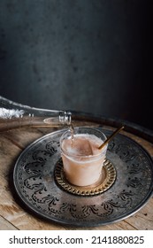 Pouring Tamarind Soda From Bottle Into Creamy Drink Cocktail. Copy Space.