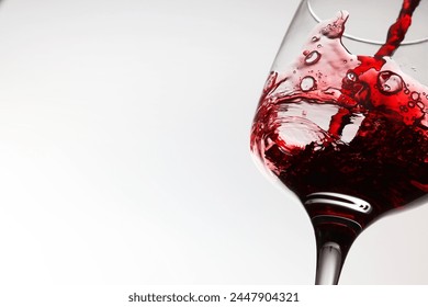 Pouring tasty red wine in glass on white background, closeup. Space for text - Powered by Shutterstock