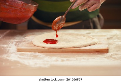 Pouring Tomato Sauce On A Pizza