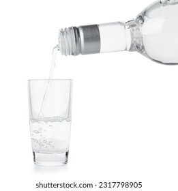 Pouring of vodka from bottle into glass on white background - Shutterstock ID 2317798905