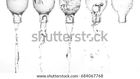 Pouring water from bottle glass isolated white background.