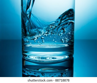 Pouring Water In Glass Closeup In Blue Light