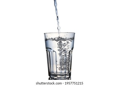 Pouring Water In The Glass Cup And Lots Of Bubbles Isolated On White Background