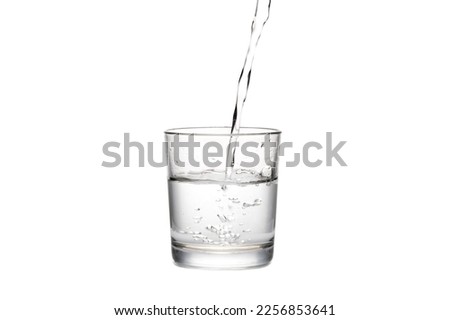 pouring water in glass, white background. clear sparkling water