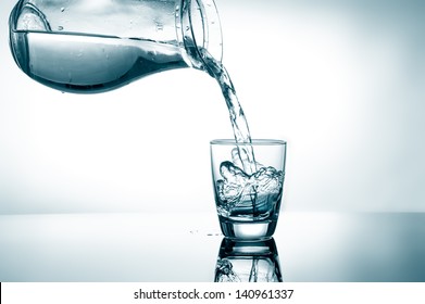Pouring Water From Pitcher Into A Glass