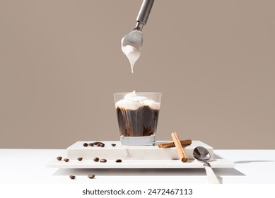 Pouring whipped cream into an Irish coffee with cinnamon on marble and brown background - Powered by Shutterstock