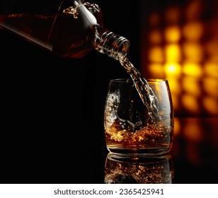 Pouring whiskey into a glass on a black background. Copy space. - Shutterstock ID 2365425941