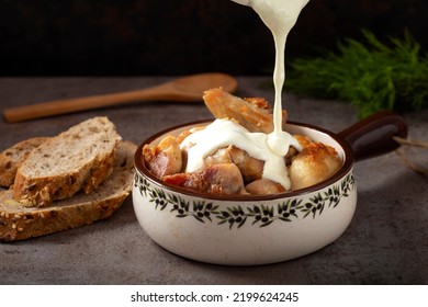 Pouring White Cream Sauce Over Pieces Of Fried Chicken Meat In Pan